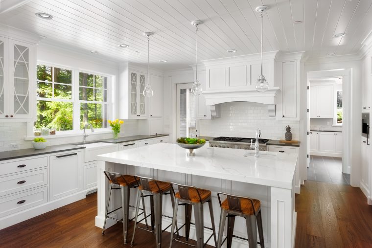 White Kitchen Interior with Island, Sink, Cabinets, and Hardwood Floors