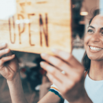 Picture of a small business owner with an open sign