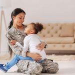 military mom playing with daughter in living room